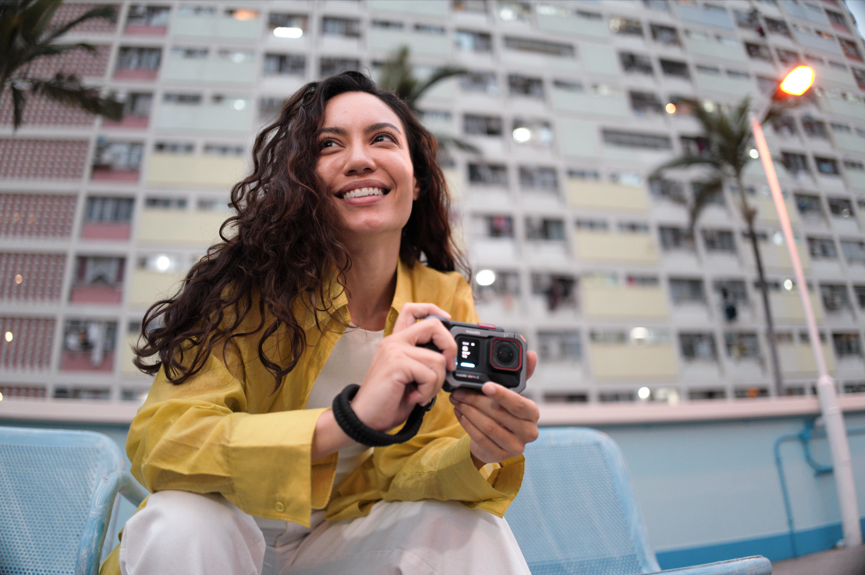 Frau bei der Streetfotografie mit Action-Kamera in der nächtlichen Stadt